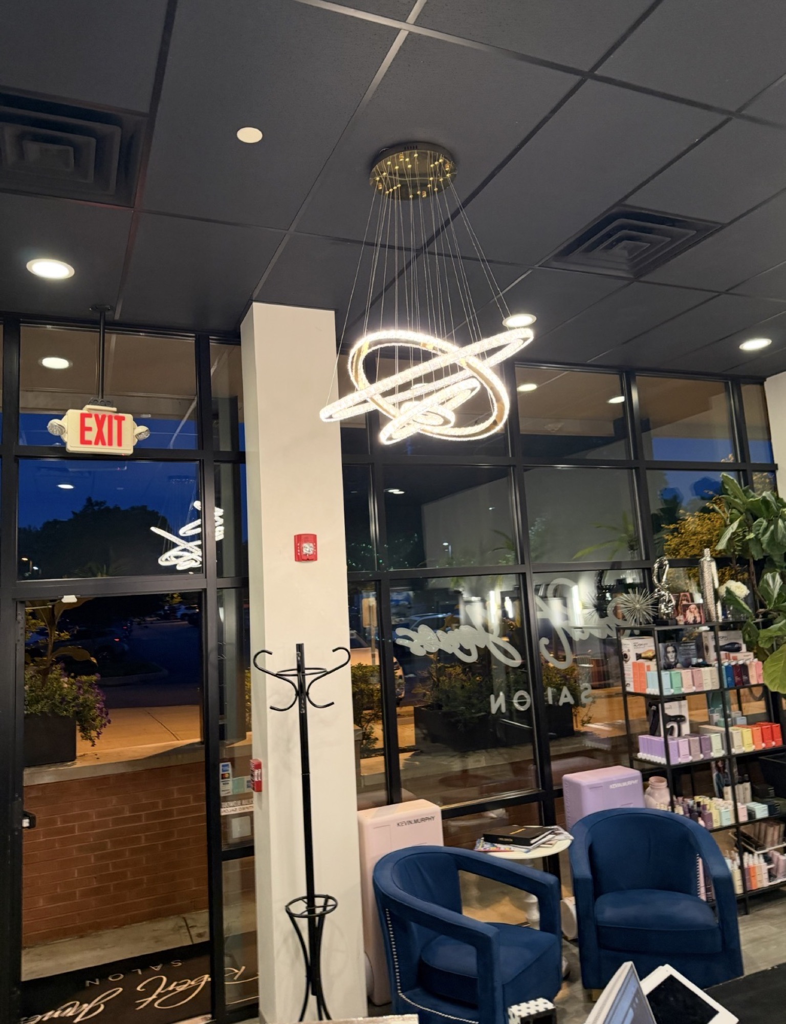 Evening interior of Robert James Salon with chandelier and retail display